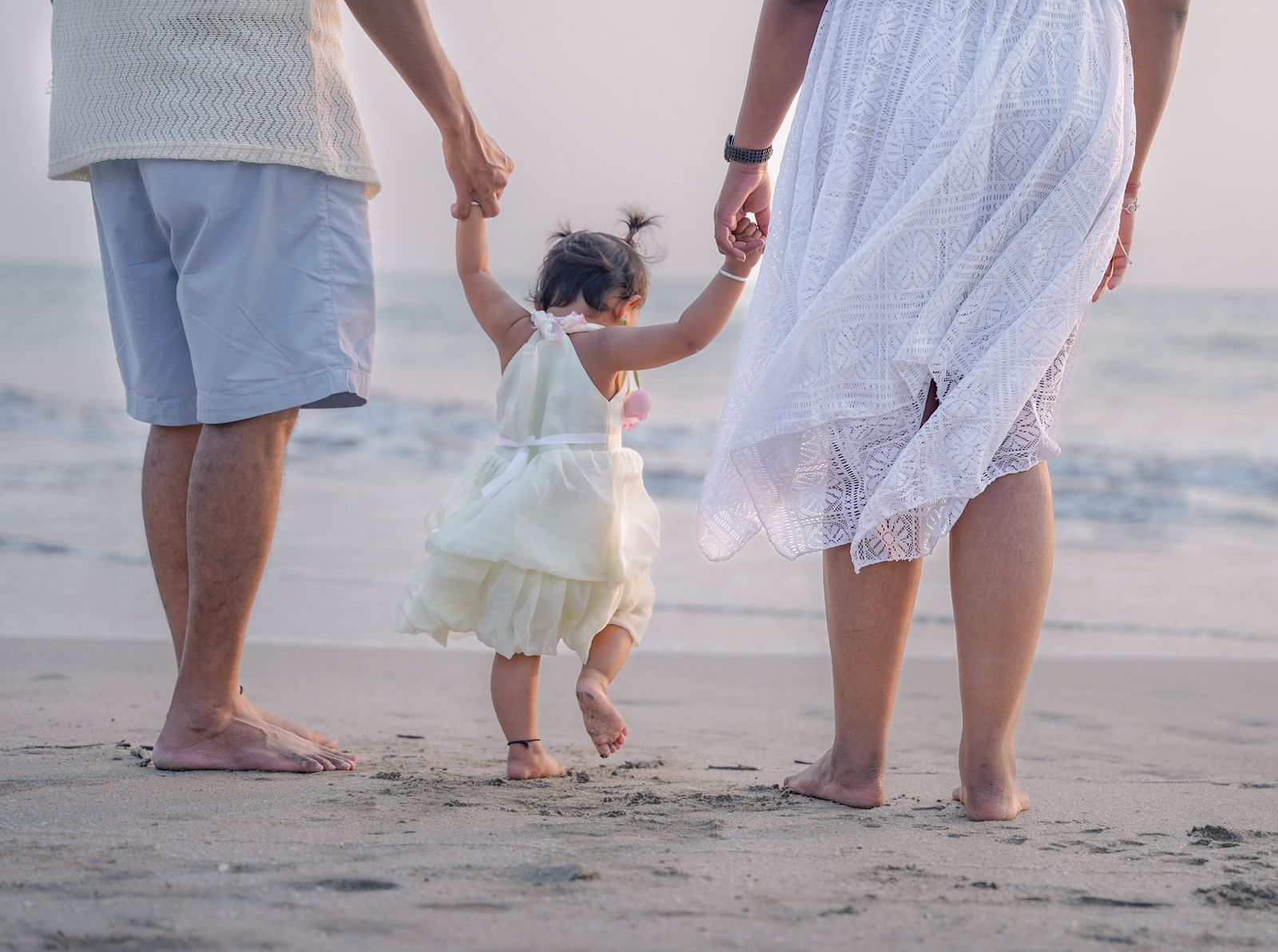 A family walking together on a sandy beach at sunset